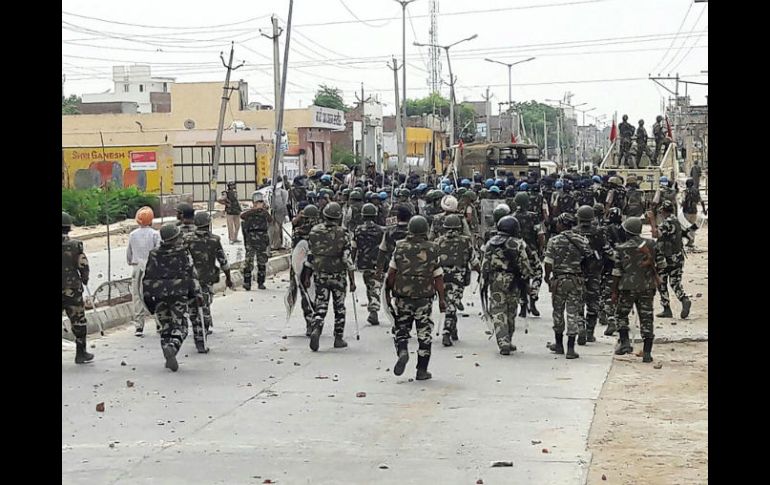 Policías buscan en los centros religiosos pertenecientes a la secta de Sing para decomisar armas. AFP /