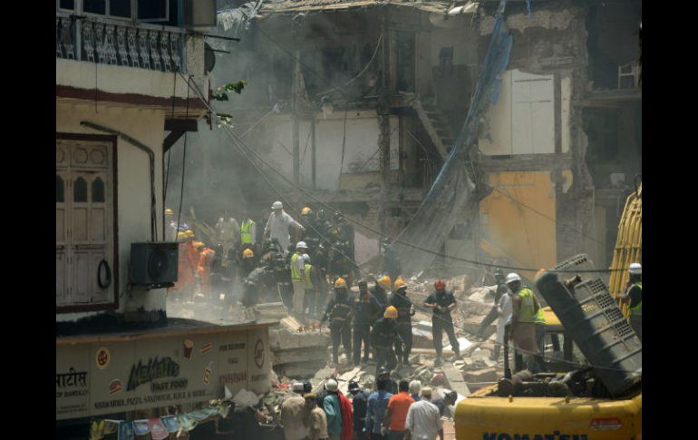 Equipos de rescate apartan a mano los restos del edificio derrumbado, ayudados por al menos una grúa de grandes dimensiones. AFP / P. Paranjpe
