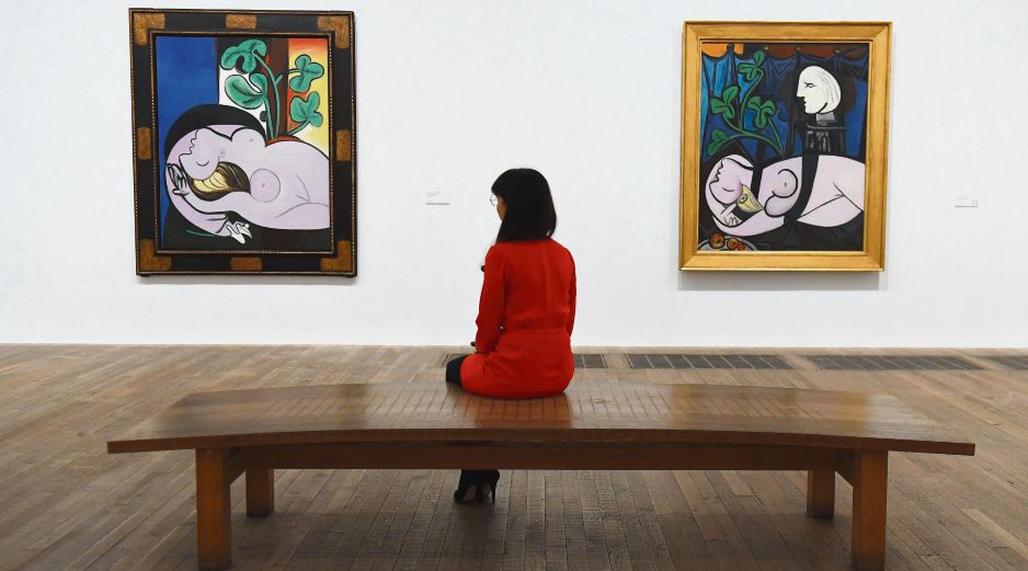 Exposición. Una empleada del museo observa las obras de Pablo Picasso “Desnudo sobre un sillón negro” (izq), y “Desnudo, hojas verdes y busto”, ambas de 1932. EFE
