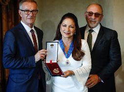 De vestido blanco entallado y acompañada de su marido Emilio Estefan, la artista acude a recibir su medalla. EFE / E. Naranja
