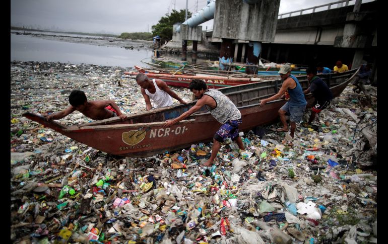 Pescadores aseguran embarcaciones en la playa en la ciudad de Bacoor, Filipinas, ante la llegada del tifón 