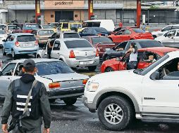 Conductores hacen fila para recargar en una estación de gasolina en Acarigua. AFP