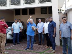 El ex presidente de Panamá, Ricardo Martinelli (c), rodeado de escoltas privados, saluda mientras sostiene a su perro Martini luego de llegar a su residencia este miércoles. EFE/B. Velasco