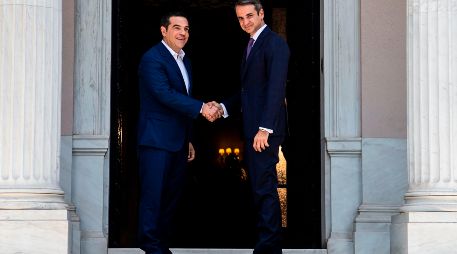 Kyriakos Mitsotakis (d) y  Alexis Tsipras se saludan en el palacio Maximus en Atenas. AFP/A. Tzortzinis