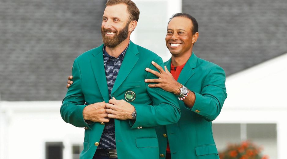 JÚBILO. Johnson (izq.) recibió la tradicional chaqueta verde de manos de Tiger Woods, quien era el campeón defensor del Masters de Augusta. AFP• P. Smith